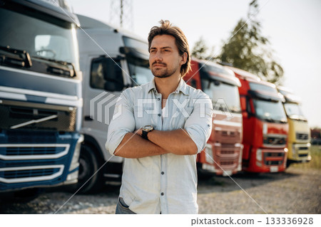 Standing with arms crossed. Truck driver is near the transport outdoors 133336928