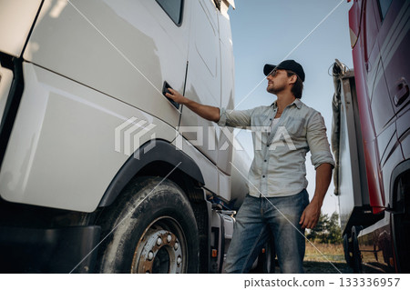 Opening the door. Truck driver is near the transport outdoors 133336957