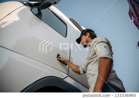 Opening the door. Truck driver is near the transport outdoors 133336960