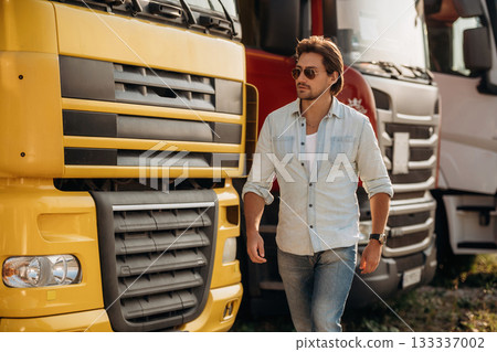 Cool look, in sunglasses. Truck driver is near the transport outdoors Cool look, in sunglasses. Truck driver is near the transport outdoors 133337002