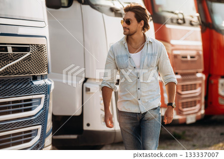 Cool look, in sunglasses. Truck driver is near the transport outdoors Cool look, in sunglasses. Truck driver is near the transport outdoors 133337007
