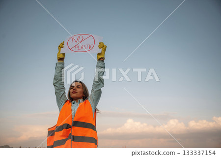 Hands holding banner with 'no plastic' text on it. Woman volunteer is against trash pollution outdoors Hands holding banner with 'no plastic' text on it. Woman volunteer is against trash pollution outdoors 133337154