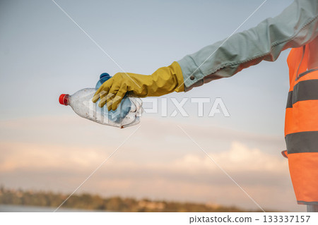 Trash pollution. Close up view of female volunteer that is holding plastic bottle. Trash pollution. Close up view of female volunteer that is holding plastic bottle. 133337157