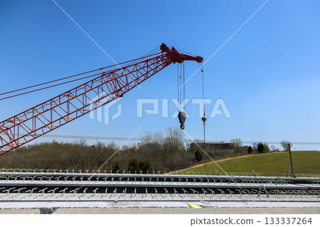 Large crane is lifting materials at concrete bridge overpass reconstruction construction site 133337264