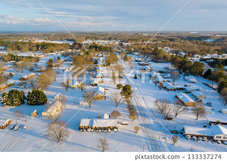 Suburban area blanketed in snow, American village highlighting homes trees on clear winter day Suburban area blanketed in snow, American village highlighting homes trees on clear winter day 133337274