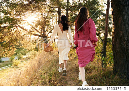 Rear view. Lovely lesbian couple are together outdoors in nature Rear view. Lovely lesbian couple are together outdoors in nature 133337545