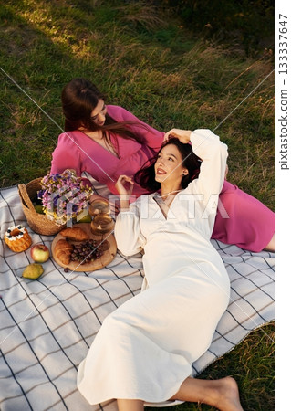 Lying down and resting. Lesbian couple is together on the picnic in nature 133337647