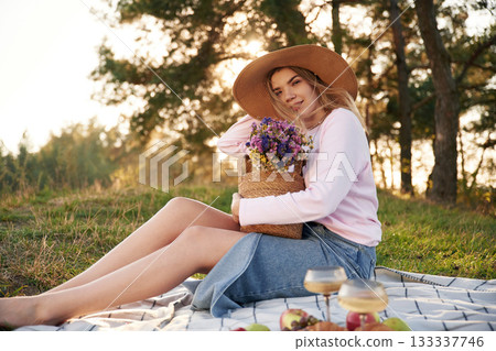 Embracing the bouquet of flowers. Woman is outdoors in nature with bouquet of flowers Embracing the bouquet of flowers. Woman is outdoors in nature with bouquet of flowers 133337746