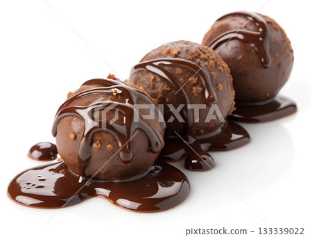Three chocolate truffles generously drizzled with melted dark chocolate sauce Three chocolate truffles generously drizzled with melted dark chocolate sauce 133339022