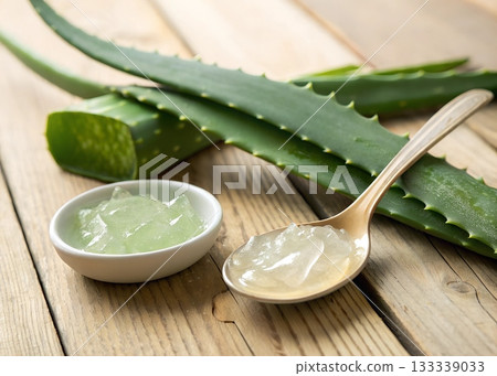 Fresh aloe vera leaves and gel in a bowl and spoon on a wooden table plant Fresh aloe vera leaves and gel in a bowl and spoon on a wooden table plant 133339033