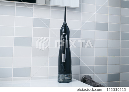 an oral irrigator on a bathroom counter 133339613