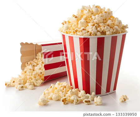 Two red and white striped containers spilling popcorn onto a white surface 133339950