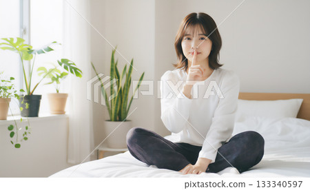 在一間充滿自然光的白色房間裡，一位神態平靜的女子的肖像 133340597