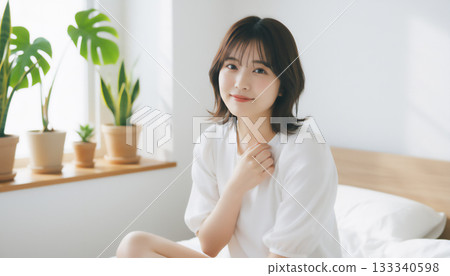 在一間充滿自然光的白色房間裡，一位神態平靜的女子的肖像 133340598