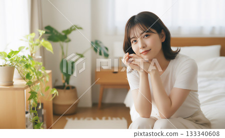 在一間充滿自然光的白色房間裡，一位神態平靜的女子的肖像 133340608