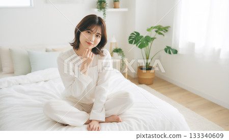 在一間充滿自然光的白色房間裡，一位神態平靜的女子的肖像 133340609