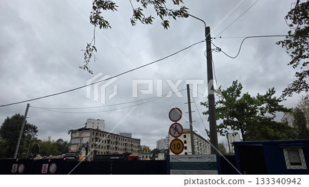 Demolition of an old high-rise building in the Moscow district. Urban development scene with cloudy sky and road signs in Moscow Demolition of an old high-rise building in the Moscow district. Urban development scene with cloudy sky and road signs in Moscow 133340942
