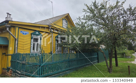 Charming wooden house in Pavlovsky Posad, Russia with vibrant yellow exterior and green fence 133340949