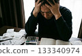 一名男子雙手抱頭，面前是家庭帳簿和收據。畫面展現了物價上漲、家庭赤字和經濟困難的景象。 133340974