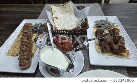 Traditional georgian cuisine display with shaslik, kebab, and sauces for culinary enjoyment Traditional georgian cuisine display with shaslik, kebab, and sauces for culinary enjoyment 133341000