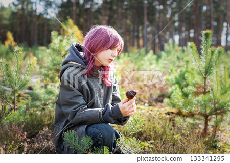 Girl with pink hair exploring mushroom in forest 133341295