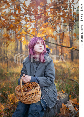 Young girl holding mushroom basket in autumn forest Young girl holding mushroom basket in autumn forest 133341296