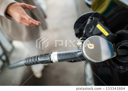 Person fueling car with diesel at gas station 133341604