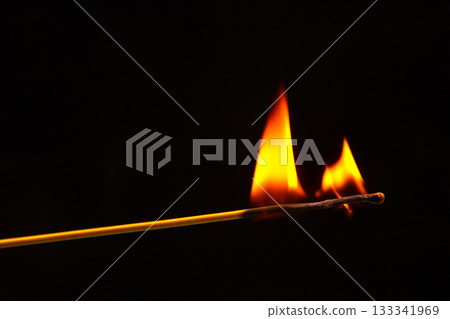 Burning wood match on a dark background close-up. burning tree fire 133341969