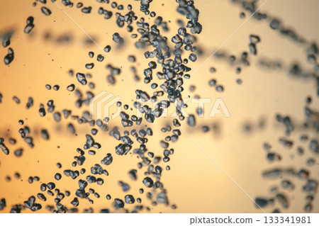 silhouettes of drops falling water fountain against the backdrop of the setting sun silhouettes of drops falling water fountain against the backdrop of the setting sun 133341981