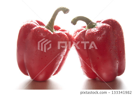 two red peppers in the water droplets on white background. two red peppers in the water droplets on white background. 133341982