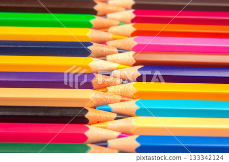 Colorful pencils in a stacked grid pattern against a white surface 133342124