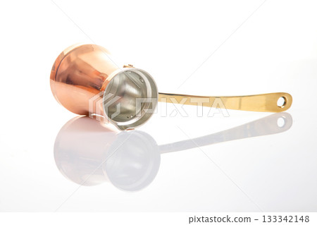 Shiny copper cezve with a golden handle, used for brewing Turkish coffee 133342148