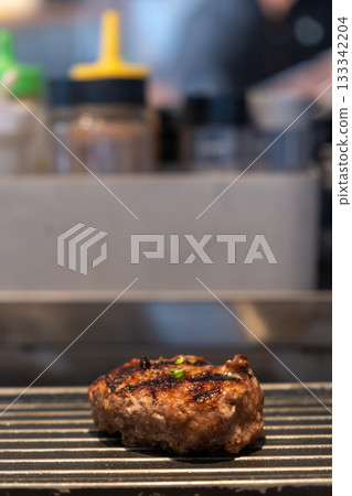 Grilled Hamburg, a patty of ground beef, on the plate with various sauce Grilled Hamburg, a patty of ground beef, on the plate with various sauce 133342204