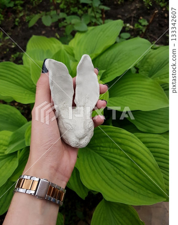 Handmade Clay Rabbit Sculpture in Lush Green Garden 133342607