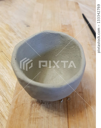 Rustic Clay Bowl: Handmade Pottery Art on Wood Rustic Clay Bowl: Handmade Pottery Art on Wood 133342769