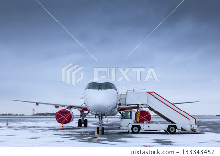 White passenger jet plane with air stairs on the winter airport White passenger jet plane with air stairs on the winter airport 133343452
