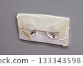The outlet with sticky tape to protect it from paint during repairs. 133343598