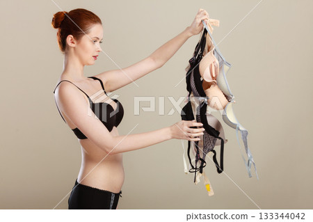 woman choosing bras to wear woman choosing bras to wear 133344042