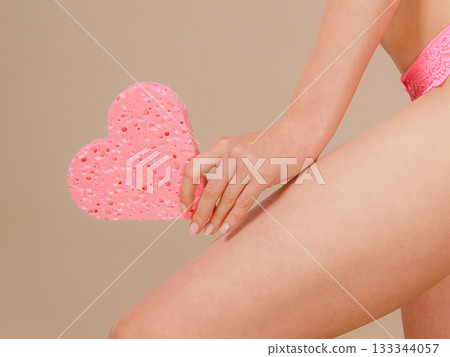 Woman holding heart shaped sponge in hand Woman holding heart shaped sponge in hand 133344057