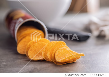 Crispy potato chips on kitchen table. 133344259
