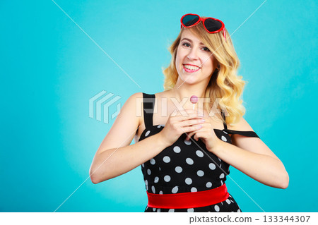 Cheerful girl holding little lollipop candy in hand 133344307