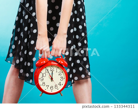girl with alarm clock on blue. 133344311