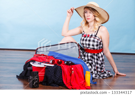 Young woman packing suitcase Young woman packing suitcase 133344317