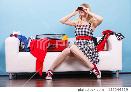 Young woman packing suitcase on couch Young woman packing suitcase on couch 133344319