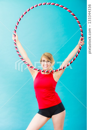Fit woman with hula hoop doing exercise Fit woman with hula hoop doing exercise 133344336
