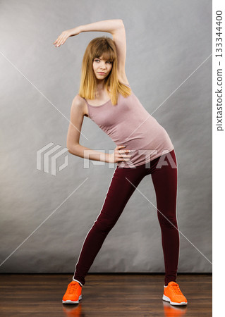 Woman working out at home stretching body 133344400