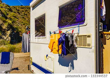 Camper rv on coast with clothes to dry Camper rv on coast with clothes to dry 133344537