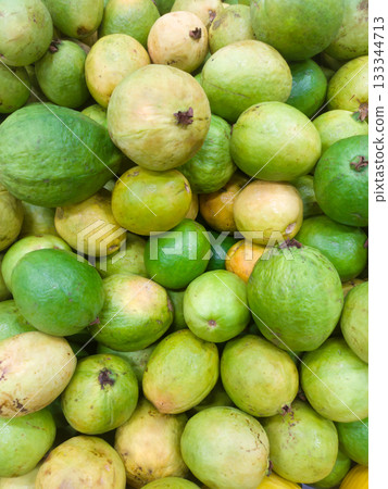 A pile of guavas stacked on a supermarket shelf 133344713