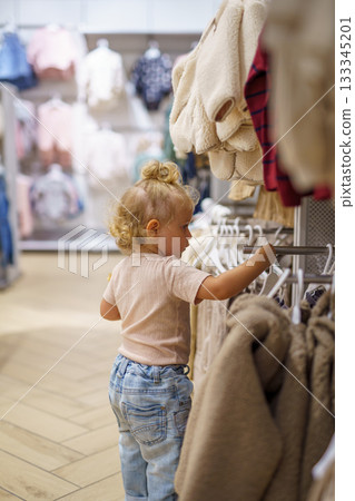 mother and daughter shopping in clothing store 133345201