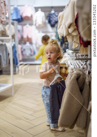 little boy chooses clothes in store little boy chooses clothes in store 133345202